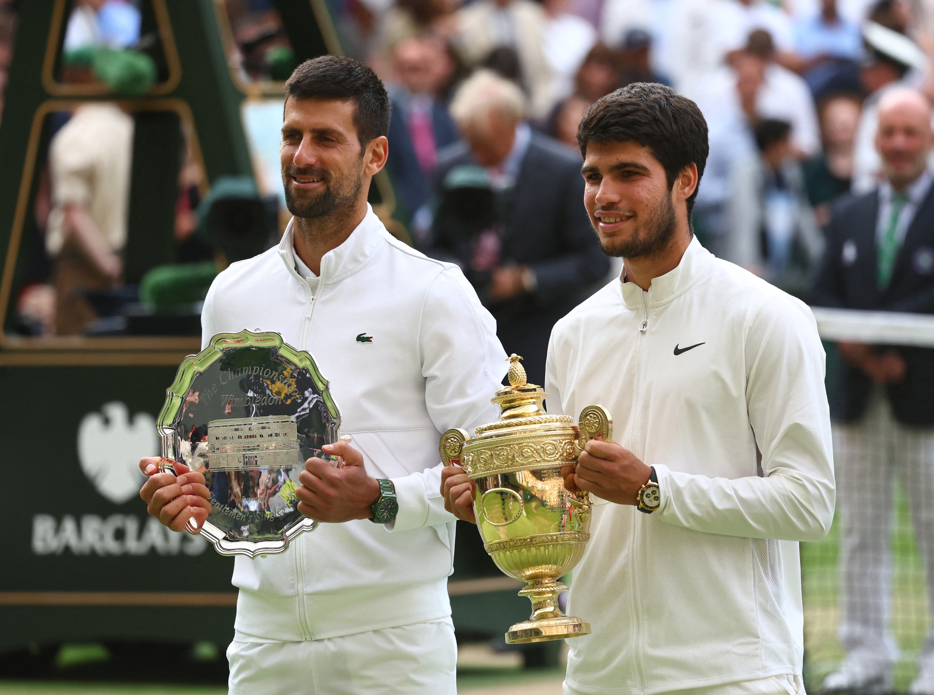 Tennis - Wimbledon - All England Lawn Tennis & Croquet Club, London, UK - JULY 16, 2023 Spaniard Carlos Alcaraz poses with the trophy after winning his final match along with Serbian runner-up Novak Djokovic REUTERS/Toby Melville